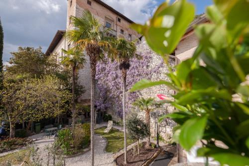 a building with palm trees in front of it at Relais Ducale in Gubbio