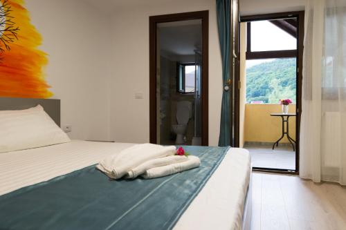 a bedroom with a bed with two towels on it at Vila Poienița Căciulata in Călimăneşti