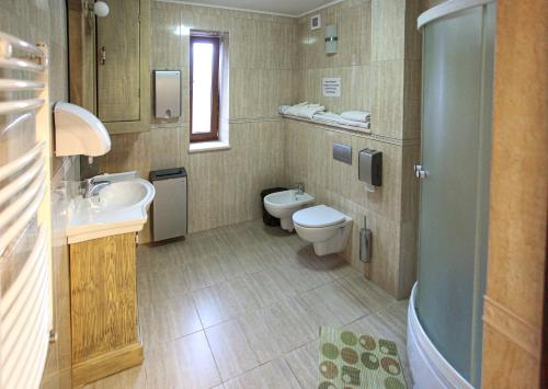 een badkamer met 2 toiletten, een wastafel en een bad bij Vila Etnica in Trebujeni
