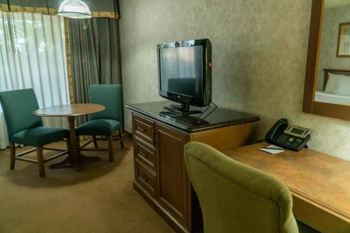 a room with a desk with a television and a telephone at Hotel Piccadilly in Fresno