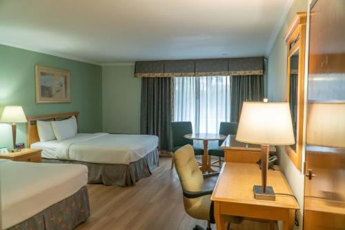 フレズノにあるホテル ピカデリーのベッド2台とテーブルが備わるホテルルームです。