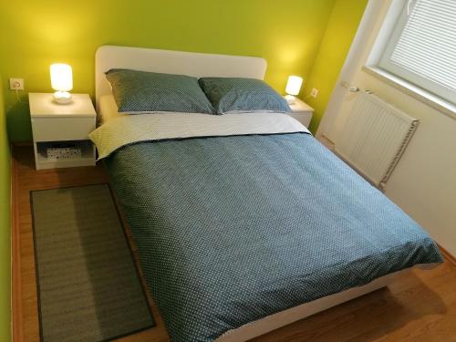 a bed in a room with two night stands and two lamps at Apartman Obadić in Gornje Vratno