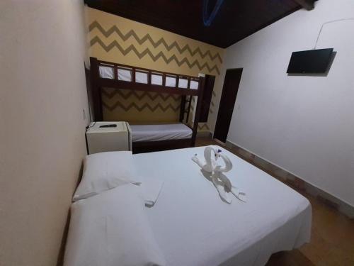 een kleine kamer met een wit bed in een kamer bij Pousada da Pipa in Pipa