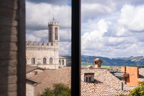 a view of a building with a clock tower from a window at Relais Ducale in Gubbio