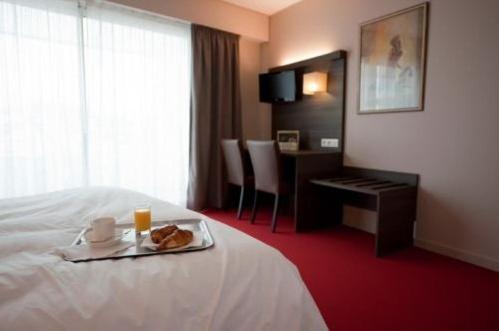 a hotel room with a tray of food on a bed at Le Robinson in Saint-Jean-de-Monts