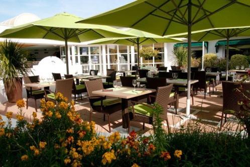 a restaurant with tables and chairs with umbrellas at Le Robinson in Saint-Jean-de-Monts