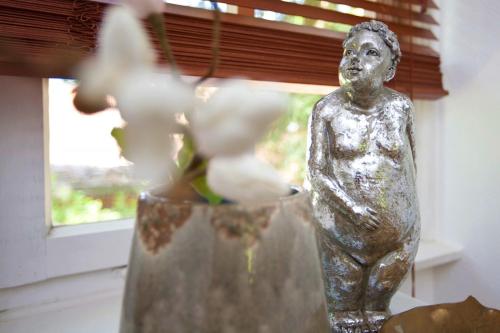 a statue of a man in a vase next to a window at FeWo Sophie (Teestube Undeloh) Lüneburger Heide in Undeloh