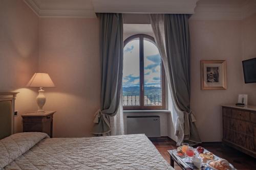 una camera con un letto e una grande finestra di Relais Ducale a Gubbio