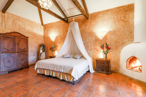 a bedroom with a bed with a canopy at Casa La Ermita in Antigua Guatemala