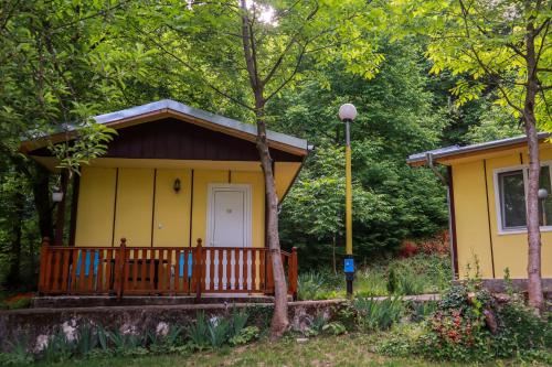 a small yellow house with a porch at Бунгала Камена - Bungalows Kamena in Kamena