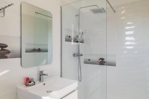 a white bathroom with a sink and a shower at Casa Andreea in Braşov