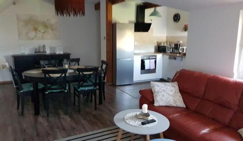 ein Wohnzimmer mit einem Sofa und einem Tisch sowie eine Küche in der Unterkunft Rauf und Justyna 1 in Wulfsen