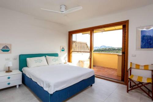 um quarto com uma cama e uma grande janela em Domus Portisco em Marina di Portisco