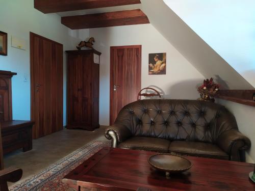 a living room with a leather couch and a table at Penzion Rozmarýn in Vsetín