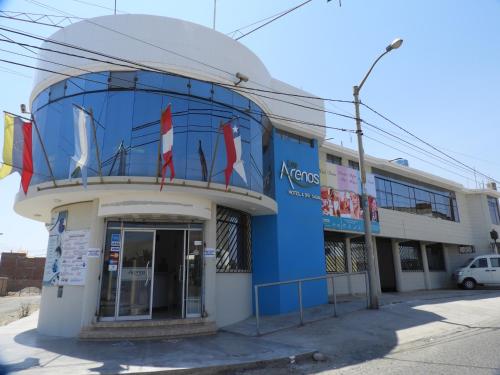 a blue and white building with flags in front of it at Arenas Hotel & Spa in Tacna