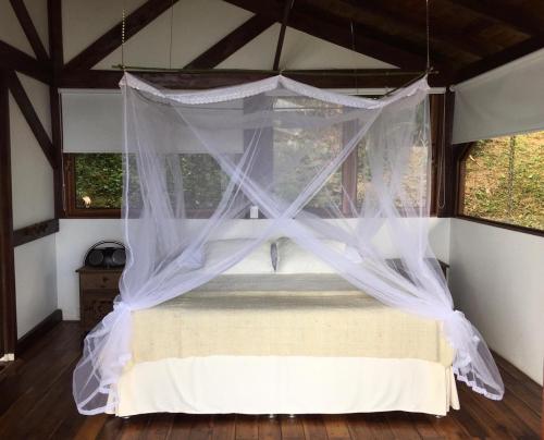 a bedroom with a bed with a canopy at Duck House Sasaima in Sasaima