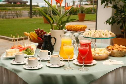 a table topped with plates of food and drinks at Casa Grande Hotel Resort & Spa in Guarujá