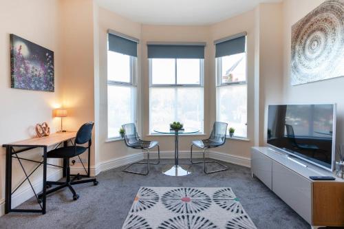 a living room with a table and chairs and windows at Beautiful, Entire Luxurious One Bedroom Flat in Leicester