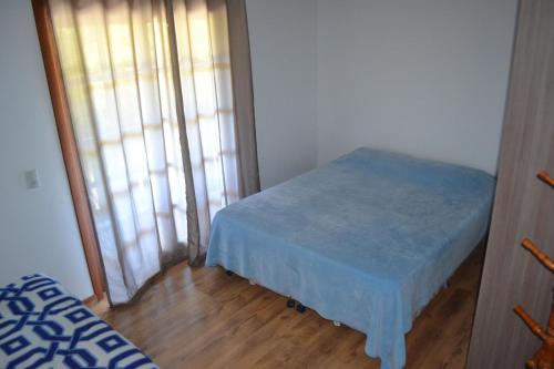 Habitación pequeña con mesa azul y ventana en Sobrado com piscina em Mariscal Rutilio N125, en Bombinhas