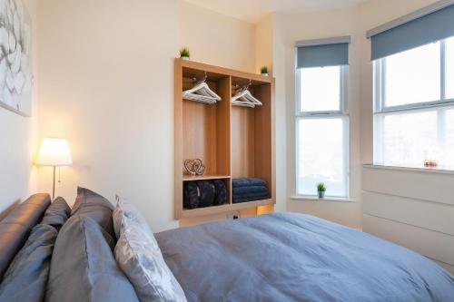a bedroom with a large blue bed and two windows at Beautiful, Entire Luxurious One Bedroom Flat in Leicester