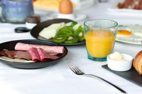 a table with a plate of food and a glass of orange juice at Bohemia Suites & Spa - Adults Only in Playa del Ingles