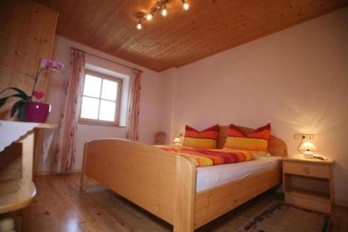 a bedroom with a bed with orange and yellow pillows at Oberschlichterhof in Longostagno