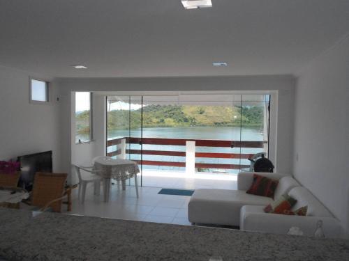 a living room with a white couch and a large window at Casa em Angra dos Reis no Paraíso do Condomínio do Engenho in Angra dos Reis