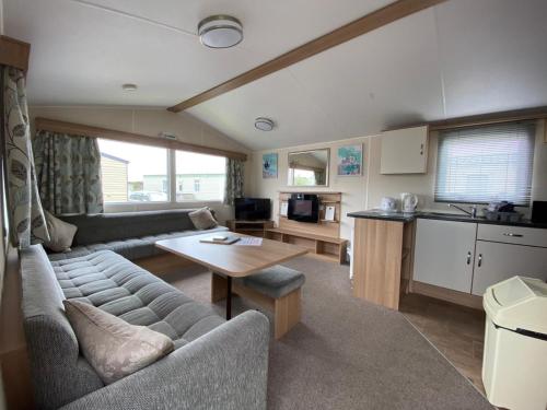 a living room with a couch and a table at Holiday in Caravan in Millom