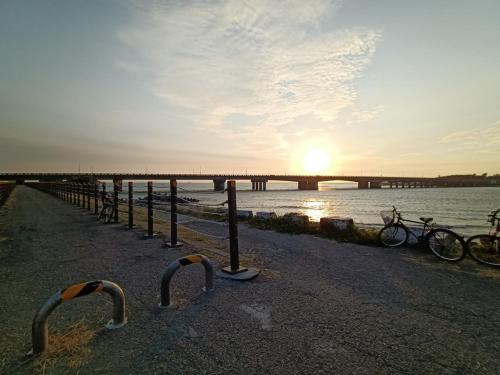 a group of bikes parked next to the water with a bridge at 安平72號民宿 in Tainan
