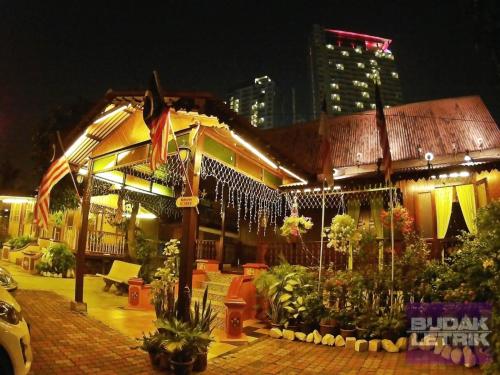 Un edificio con le luci di Natale che pendono di notte di JOKA-JOKA GUESTHOUSE a Malacca