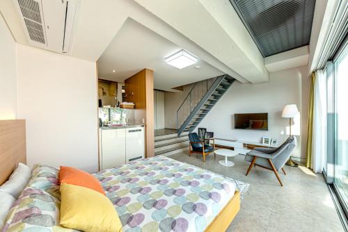 a bedroom with a large bed and a staircase at Jeju Bom stay & Art Gallery in Seogwipo