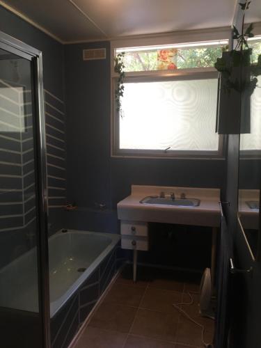 a bathroom with a tub and a sink and a window at Grampians Nest in Halls Gap
