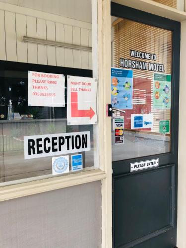 a store front with signs on the window at Horsham Motel in Horsham