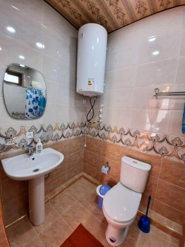 a bathroom with a sink and a toilet and a mirror at Зона отдых APACHI в горах ЧИМГАН in Chimgan