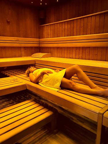 a woman laying on a bed in a sauna at Hotel Casino in Sierre