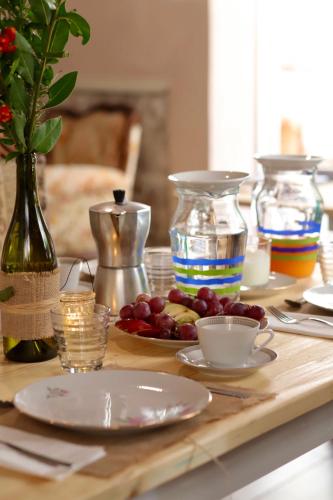 a table with plates and bowls of fruit on it at Corte Boero Bed&Breakfast in Capoterra