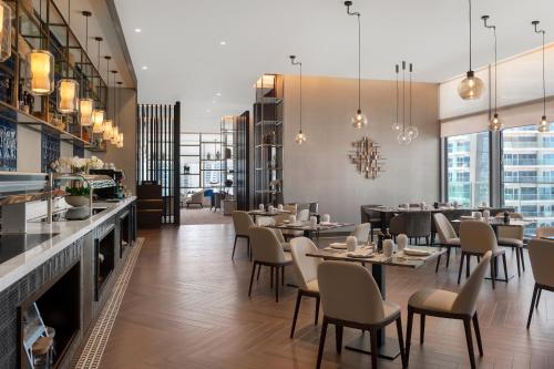 a restaurant with tables and chairs and a bar at Jumeirah Living Marina Gate Dubai in Dubai