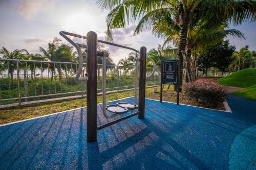 a playground with a swing and some palm trees at Timurbay by Seascape in Kuantan