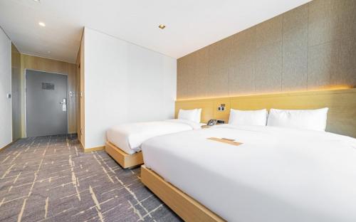 a hotel room with two beds and a hallway at Sea Cruise Hotel in Sokcho