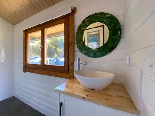 a bathroom with a bowl sink and a window at Bretts Rest AZA in Kingscote