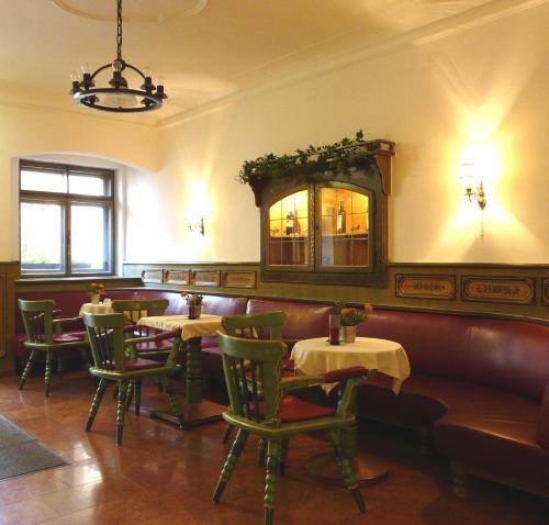 ein Restaurant mit Tischen, Stühlen und einem Spiegel in der Unterkunft Hotel Schwarzes Rössl in Salzburg