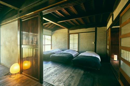 Postel nebo postele na pokoji v ubytování 古民家宿るうふ 丘之家 Okanoie