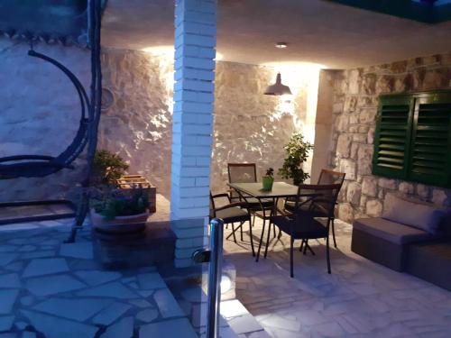 a patio with a table and chairs and a stone wall at Bluesun Sibenik Apartments in Šibenik
