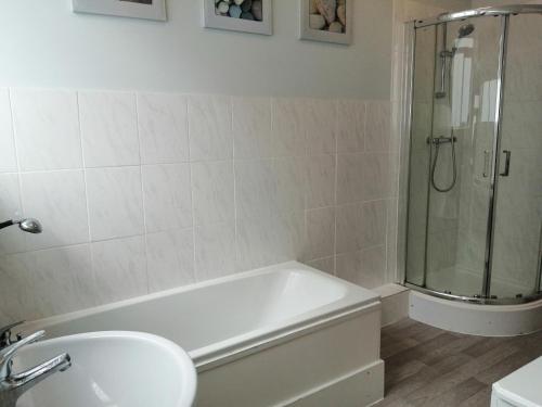 ein Badezimmer mit Badewanne, Waschbecken und Dusche in der Unterkunft Lazy Days in Bournemouth