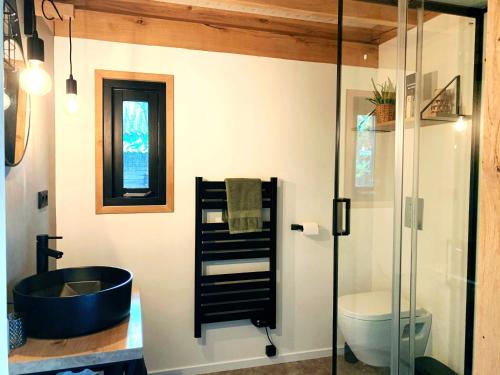 a bathroom with a black tub and a toilet at Hoogtij°d in Oostvoorne