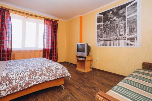 a hotel room with a bed and a tv at Apartmens Faraon On Illinskaya New Building 6 floor in Sumy