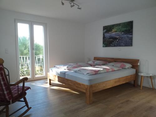 a bedroom with a bed and a chair and a window at Kleine Auszeit in Rust