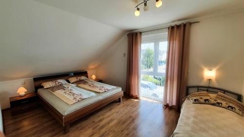 a bedroom with two beds and a large window at Ferienwohnung Valerie in Ettenheim