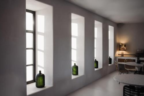 a row of windows with green bottles in a room at Koukoumi Vegan Boutique Hotel in Ano Mera