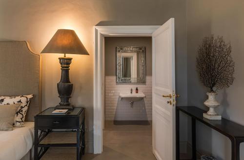 a bedroom with a bed and a sink in a bathroom at Seven Rooms Villadorata in Noto